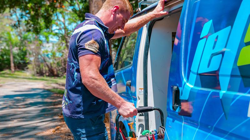 Tradie packing up tools at the van at the end of a long day