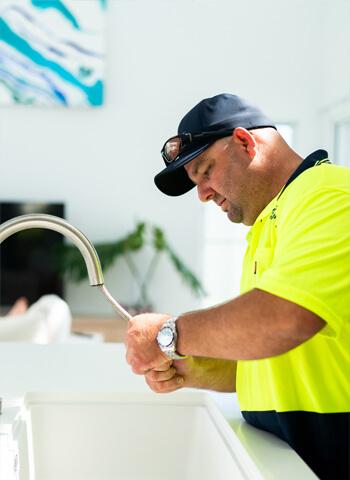 Plumber working under a sink